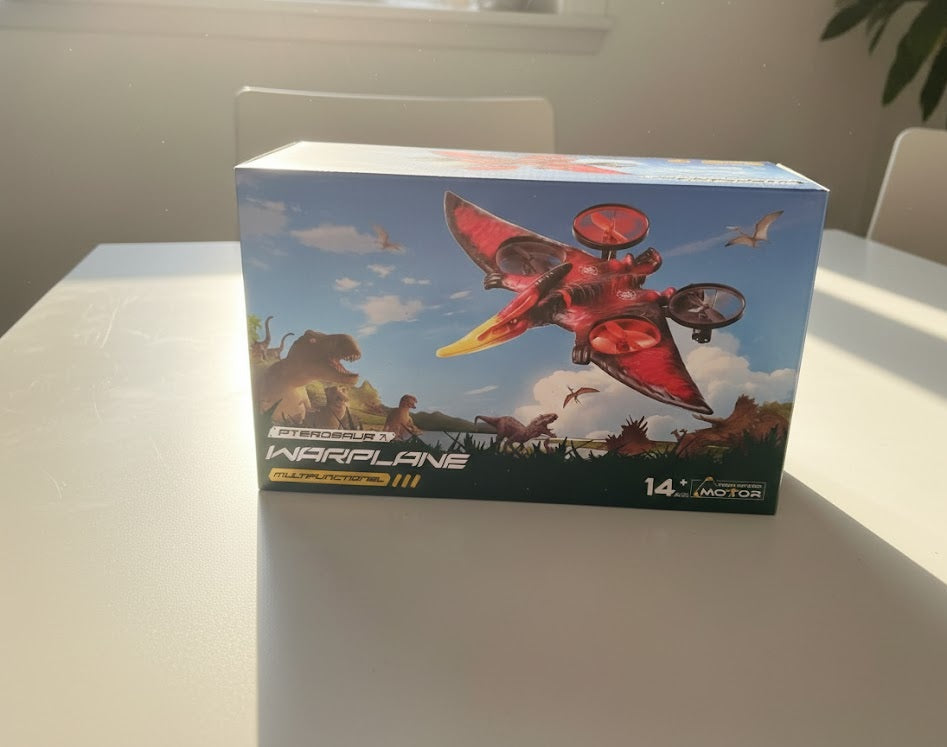 Box of a red toy warplane with a dinosaur and sky background on a white surface.  Fast shipping all over dubai Orenza.store