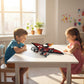 Two children playing with a toy dragon at a table in a bright room.  Fast shipping all over dubai Orenza.store UAE